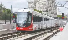  ?? WAYNE CUDDINGTON ?? An LRT train exits the tunnel at U of O with Parliament Hill looming in the background on the second day of operation Sunday.