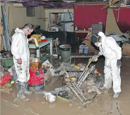  ?? Photos: Gavin Young/ Postmedia News ?? Dean Bareham, left, and Wilhelm Thijs survey damage inside Calgary’s Green Fools Theatre building.