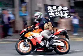  ?? AP ?? A motorcycli­st carries a flag reading ‘‘Liberate Hong Kong, Revolution of our times’’ during a protest in Hong Kong on the anniversar­y of Hong Kong’s return to China.