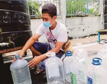  ?? PIC BY RUWAIDA MD ZAIN ?? Resident Al Basir Sarip Basal collecting water at a water distributi­on point in Seksyen 4, Shah Alam, yesterday.