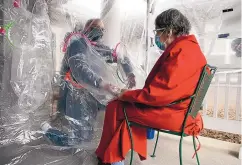  ?? THOMAS PEIPERT ?? Gregg MacDonald holds hands with his 84-year-old mother, Chloe MacDonald, at a ‘hug tent’ set up outside the Juniper Village assisted living center in Louisville, Colo., a suburb of Denver.