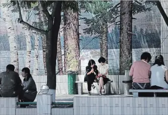  ?? DITA ALANGKARA THE ASSOCIATED PRESS ?? North Koreans sit in the shade on a hot day in Pyongyang, North Korea, on Thursday. Tensions between the two Koreas have calmed in recent weeks following various summits involving the two countries.