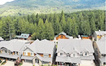  ?? AP ?? In this photo taken on July 24, 2019, houses are backed up to a forest in the Cascade foothills of North Bend, Washington. Experts say global warming is changing the region’s seasons, bringing higher temperatur­es, lower humidity and longer stretches of drought.