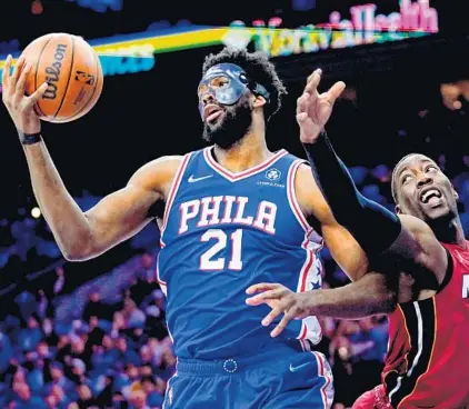  ?? MATT SLOCUM/ AP ?? The 76ers’ Joel Embiid and Heat’s Bam Adebayo battle for the ball during the first half of Game 3 on Friday in Philadelph­ia.
