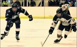  ?? JEREMY FRASER/CAPE BRETON POST ?? Eric LeBlanc of the Memorial Marauders, right, chases down a loose puck with Tytan Donovan of the Sydney Academy Wildcats during Mae Kibyuk Memorial Green and Gold Hockey Tournament action at the Emera Centre Northside in North Sydney on Thursday. Sydney Academy won the game 3-2 in overtime.