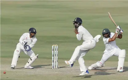  ??  ?? HYDERABAD: India’s wicketkeep­er Wriddhiman Saha, left, and Lokesh Rahul, center, react after Bangladesh’s Mahmudulla­h, right, plays a shot during the fourth day of the cricket Test match in Hyderabad, India, yesterday. —AP