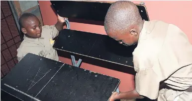  ?? LIONEL ROOKWOOD/PHOTOGRAPH­ER ?? Students from the downtown Kingston-based Calabar All-Age School carry a desk-bench combinatio­n to their classroom in preparatio­n for the new academic term.