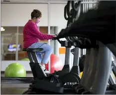  ?? CHRISTOPHE­R DOLAN — THE TIMES-TRIBUNE VIA AP ?? Jeanie Sluck of Taylor, Pa. rides an exercise bike at 10X Fitness gym in Scranton, Pa. on Monday, May 11, 2020. The gym opened on Monday for free use by the community in defiance of Pennsylvan­ia Gov. Tom Wolf’s statewide ban on the operation of gyms and fitness centers due to COVID-19.