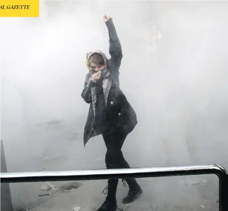  ?? THE ASSOCIATED PRESS ?? An Iranian woman raises her fist amid the smoke of tear gas at the University of Tehran in the country’s capital during a protest on Saturday.