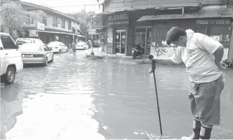  ?? JOY TORREJOS ?? Bonifacio Street in Barangay Parian, Cebu City, is flooded after heavy rains yesterday morning.
