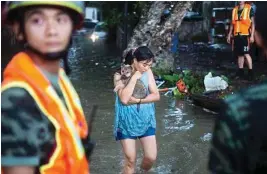  ?? AP/PTI ?? A woman holds on to her pet as they evacuate from flood waters caused by Typhoon Hato and the tide in southern China’s Guangdong province