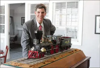  ?? CORNELIUS FROLIK / STAFF ?? Brady Kress, president and CEO of Dayton History, displays a mini replica of the Cincinnati, the first locomotive to pull a passenger train into Dayton. Carillon Historical Park is acquiring a full-sized replica of the train that will travel along a one-mile track that visitors can ride.