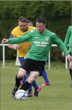  ??  ?? Gary Byrne of North End Unite closes in on Michael Kinsella of Courtown Hibs.