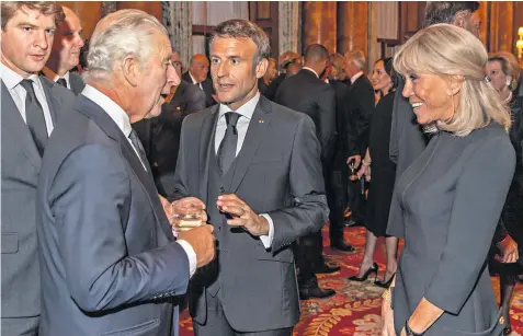  ?? ?? The King greets Emmanuel Macron, the French president, and his wife, Brigitte, during a reception for heads of state and overseas visitors at Buckingham Palace last Sunday night