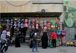  ?? AP ?? Syrians shop at the hamadiyah market in the old City of Damascus on Thursday. The streets of Damascus were packed with people on Thursday evening either going out to shop in one of the city’s main markets to hanging out with families and friends at the...
