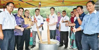  ??  ?? Gambar kiri RIBIN dan Harun menggaul bubur pisang sebelum diagihkan kepada orang ramai.