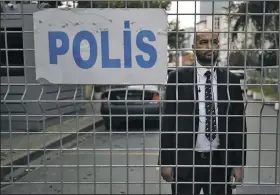  ?? AP/EMRAH GUREL ?? A security guard looks out Saturday from the road leading to the Saudi Arabian Consulate in Istanbul.