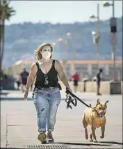  ?? Jay L. Clendenin Los Angeles Times ?? DOGS, with their humans home, are constantly being taken for walks, above in Hermosa Beach and all over.