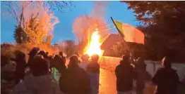  ?? ?? Blaze: Protesters wave a tricolour at the Wicklow complex