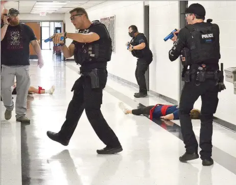  ?? TIMES photograph­s by Annette Beard ?? Pea Ridge Lt. Rich Fordham, left, as the officer in charge of the training, observes Pea Ridge, Bella Vista and Little Flock Police officers as they worked together training Tuesday and Thursday in an active shooter drill in Pea Ridge Junior High School. For more photograph­s, go to the PRT gallery at https://tnebc.nwaonline.com/photos/.