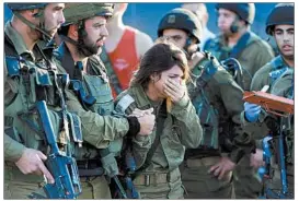  ?? AHMAD GHARABLI/GETTY-AFP ?? An Israeli soldier reacts Monday at the scene of a soldier’s stabbing death. The attack by a Palestinia­n happened a day after a Palestinia­n man fatally stabbed an Israeli woman.