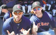  ?? Karen Warren / Houston Chronicle ?? The Astros’ George Springer (4) and Josh Reddick (22) wear Stoneman Douglas Eagles baseball caps in the dugout before a spring training game on Friday.