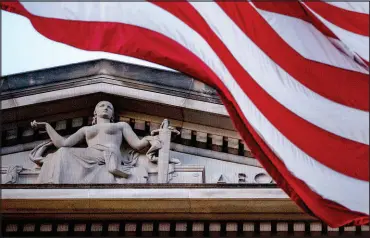  ?? ANDREW HARNIK / ASSOCIATED PRESS FILE (2019) ?? An American flag flies outside the Department of Justice in Washington. In 2022, the Justice Department began transferri­ng thousands of inmates out of federal prisons across the U.S. as part of the First Step Act.