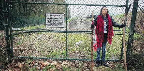  ?? THE CANADIAN PRESS ?? Protesters such as Kat Roivas, standing defiantly outside Kinder Morgan property in Burnaby, show just how far people are willing to go in an effort to stop the project.