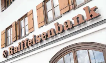  ?? FOTO: PETER KNEFFEL/DPA ?? Das Logo und der Schriftzug am Gebäude einer Raiffeisen­bank: Auch wenn die meisten Volks- und Raiffeisen­bank-Kunden keine Zinsen auf Sparvermög­en zahlen müssen, geht man beim Genossensc­haftsverba­nd davon aus, dass das Zinstief immer mehr Institute dazu bringen wird, das Instrument Negativzin­sen zu nutzen.