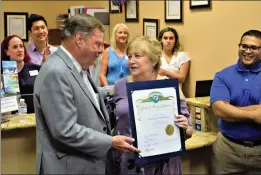  ?? Tammy Murga/The Signal ?? Councilman Bob Kellar presents a congratula­tory certificat­e to Nola Aronson, the owner of Advanced Audiology, on behalf of the city on Friday.