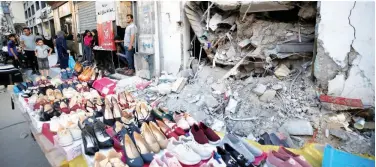  ?? Reuters ?? ↑ A Palestinia­n sells shoes ahead of Eid Al Adha in Gaza City on Sunday.