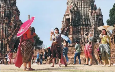  ?? UARAWEE KITTISILPA / REUTERS ?? People dressed in traditiona­l costumes pose for a picture, as interest for historical clothing rises within the country, in Ayutthaya, Thailand, on Friday.