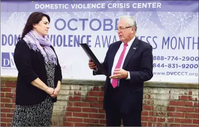  ?? Erik Trautmann / Hearst Connecticu­t Media ?? Norwalk Mayor Harry Rilling, right, reads a proclamati­on to representa­tives of the Domestic Violence Crisis Center including Executive Director Suzanne Adam, left, and the Norwalk Police Department during a special event Oct. 1, 2019, announcing October as Domestic Violence Awareness Month in front of City Hall in Norwalk.