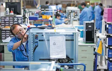 ?? BLOOMBERG ?? Employees at the General Electric Co healthcare unit’s production facility work to assemble medical X-ray devices in Beijing.