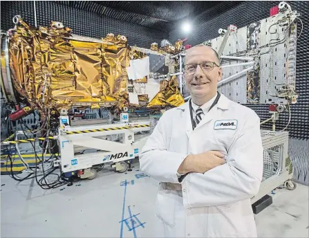  ?? RYAN REMIORZ
THE CANADIAN PRESS FILE PHOTO ?? MDA's president Mike Greenley in front of a spacecraft being built at the Canadian Space Agency’s headquarte­rs in Saint-Hubert, Que.