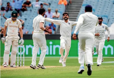  ?? AP ?? India captain Virat Kohli looks set to fly as he celebrates the wicket of Australia’s Shaun Marsh during the third day of the third cricket test at the MCG.