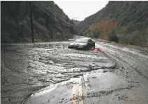  ?? Katie Falkenberg / Los Angeles Times ?? A car gets stuck in the mud that slid down steep slopes onto Topanga Canyon Boulevard in Los Angeles County.