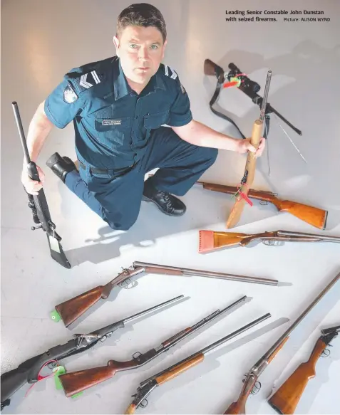  ?? Picture: ALISON WYND ?? Leading Senior Constable John Dunstan with seized firearms.