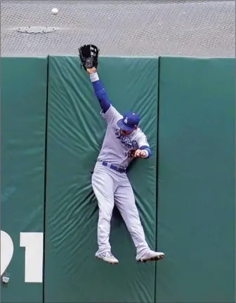  ?? Jeff Chiu Associated Press ?? DODGERS CENTER FIELDER Cody Bellinger leaps but can’t catch a home run hit by the Giants’ Austin Slater to lead off the bottom of the first inning. The loss completed a three-game series sweep.