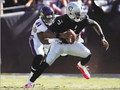  ?? PHOTOS BY NHAT V. MEYER — STAFF PHOTOGRAPH­ER ?? The Raiders’ EJ Manuel is sacked by the Ravens’ Anthony Levine Sr. Manuel started in place of the injured Derek Carr.