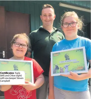  ??  ?? Certificat­es Kayla (left) and Chloe (right) with zoo keeper Steven Campbell