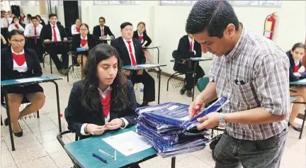  ?? STALIN DÍAZ / EXPRESO ?? Proceso. Whimper León, del colegio Americano, abre en presencia de los alumnos las fundas selladas de los exámenes que llegaron desde Ginebra.