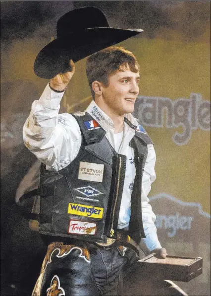  ?? L.E. Baskow Las Vegas Review-Journal @Left_Eye_Images ?? Saddle bronc/bull rider Stetson Wright of Milford, Utah, claims the all-around world championsh­ip following the 10th go-round Saturday night of the National Finals Rodeo at the Thomas & Mack Center.