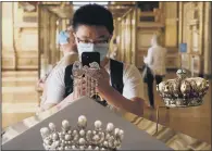  ?? PICTURES: GETTY IMAGES ?? ARTWORKS: From top, visitors wearing face masks stand in front of The Interventi­on of the Sabine Women by Jacques-Louis David; a visitor takes a photo of Empress Eugenie’s jewellery.