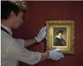  ??  ?? A handout picture released by Sothebys shows an assistant holding a self-portrait by Dutch artist Rembrandt in London. — AFP