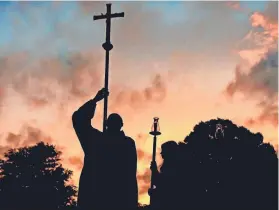  ??  ?? Matthew Sorg waits to lead the procession at the opening of the 32nd annual Easter Sunrise Mass at Calvary Cemetery. Hundreds of Memphis-area Catholics filled folding chairs and camp seats or laid out on blankets to celebrate Easter as the sun rose.