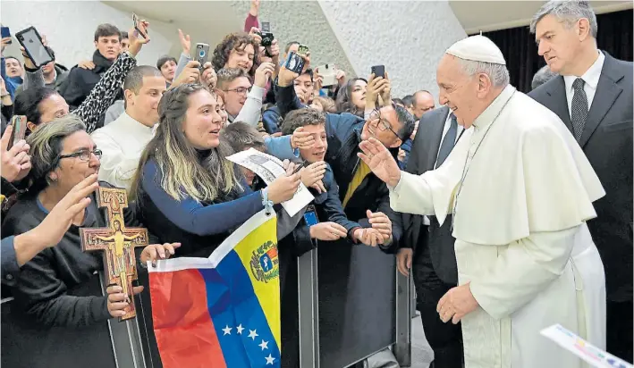  ?? ANSA ?? Encuentro. Junto a una bandera de Venezuela, el Papa saluda a periodista­s de la agencia ASCA durante la audiencia general de los miércoles en el Salón Paulo VI del Vaticano.