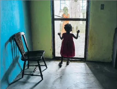  ?? THE WASHINGTON POST / GETTY ?? Desprotegi­das Una niña observa el exterior desde una de las viviendas que tiene la oenegé More Than Me en la zona más desfavorec­ida de la capital de Liberia, Monrovia