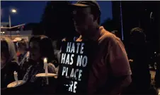  ??  ?? BELOW: Rex Clemons (from right) holds a sign that says “hate has no place here” while standing with Debra Defoor and Angie Childers.
Photos by Spencer Lahr, RN-T