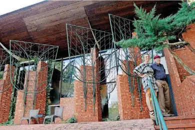  ?? [PHOTOS BY DOUG HOKE, THE OKLAHOMAN] ?? Joy Baresel and architect Herb Greene stand in the backyard patio of the home known as the Cunningham Residence, which Greene designed and executed in 1962. Greene visited the new owners, Joy and Paul Baresel to talk about remodeling ideas for the home...